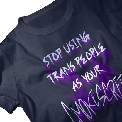 Navy unisex t-shirt with bold purple and white graffiti-style text that reads “Stop Using Trans People As Your Smokescreen.” Statement activism shirt for Pride and LGBTQ+ allies.